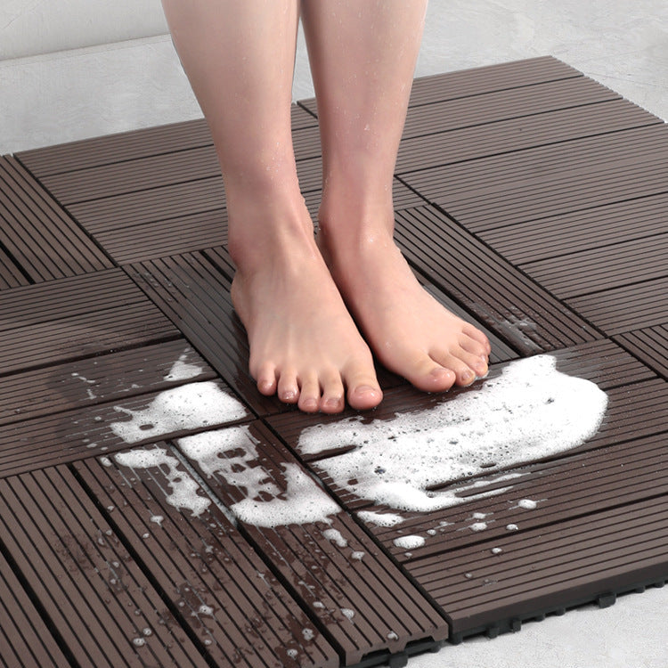 Person standing on a brown interlocking foam mat with soapy water splashes.
