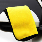 Yellow microfiber towel draped over a car mirror with a black border.